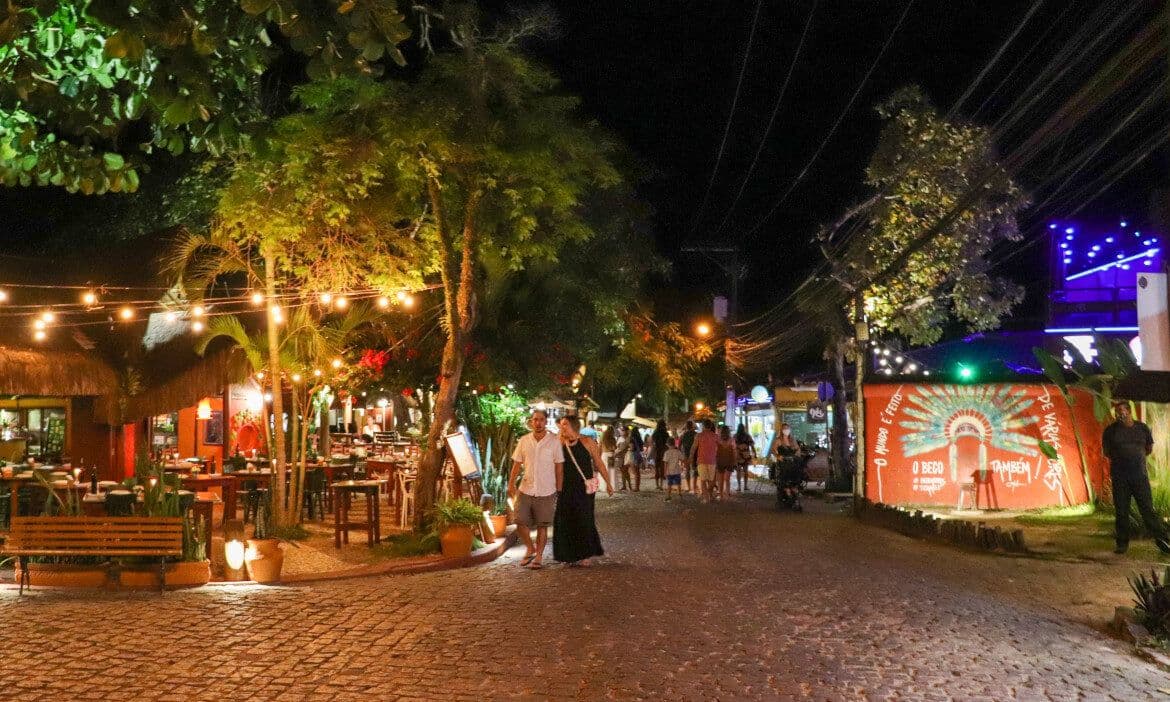 Rua do Mucugê iluminada à noite, em Arraial d'Ajuda